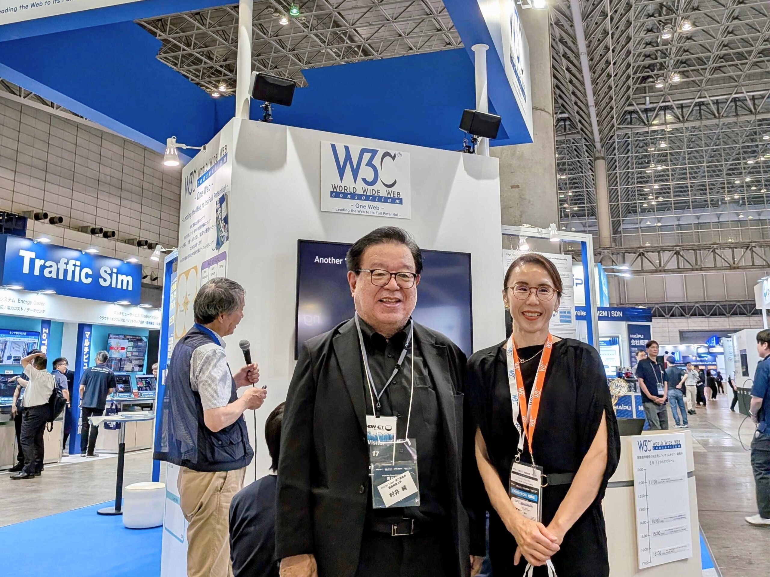 ブース前にてW3C/Keio代表村井純先生（中央）と吉澤直美事務局長（右）の写真